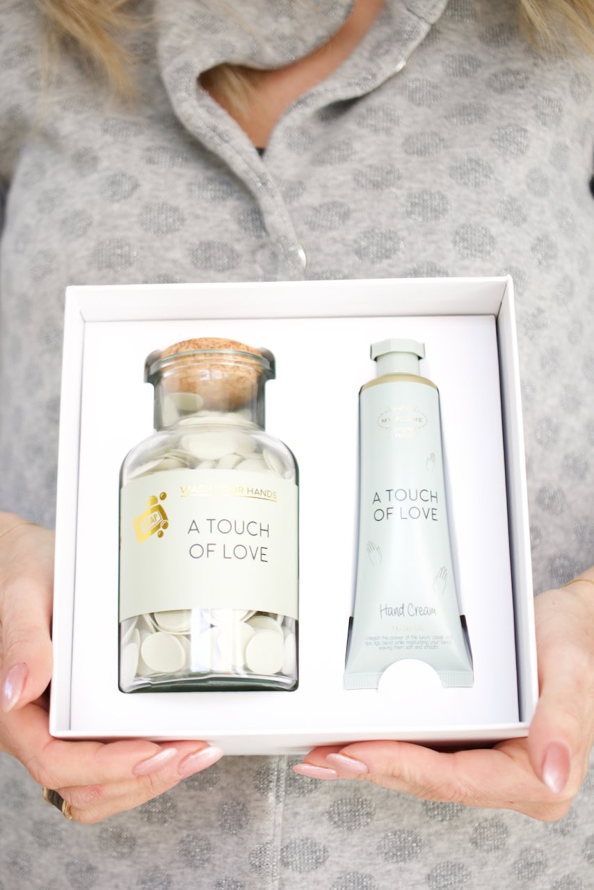 Bottiglia di profumo e crema corpo in confezione regalo bianca elegante.