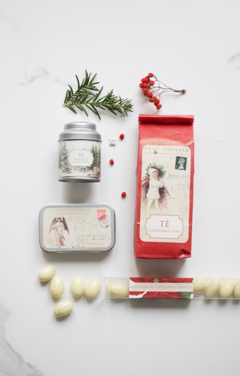 Tè in confezione elegante con decorazioni natalizie e foglie di pino, ideale per regali e momenti di.