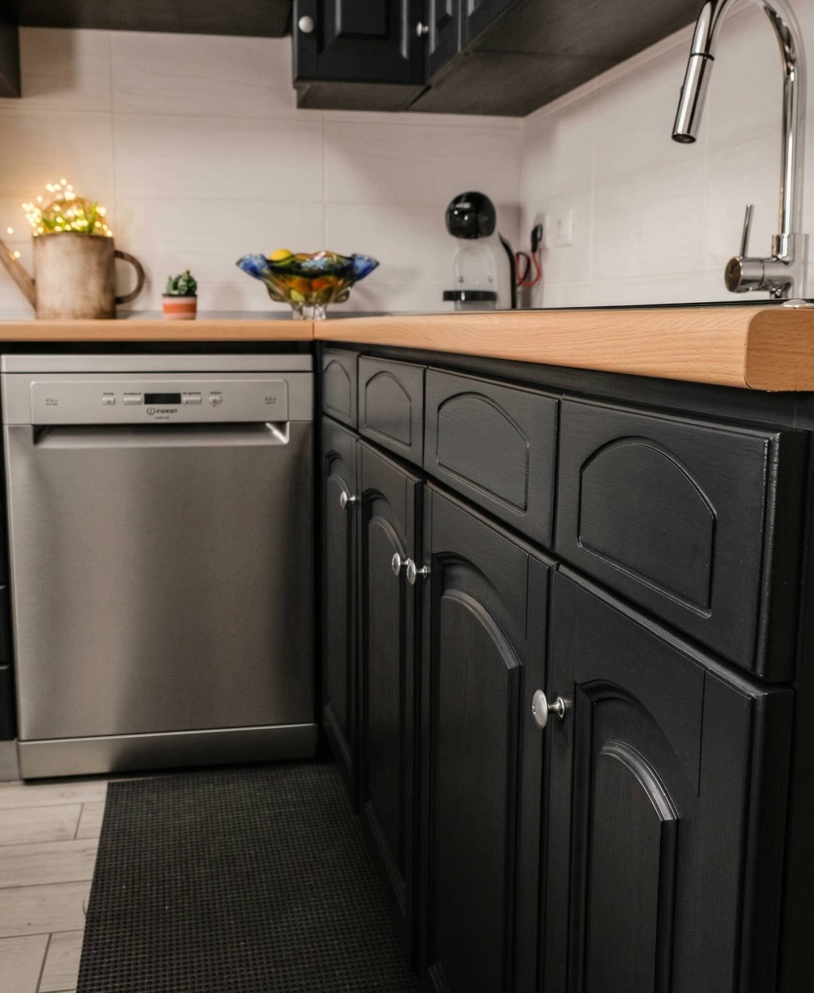 cucina nera ridipinta Lavastoviglie in cucina con mobili neri e piano in legno chiaro, dettagli moderni e funzionali.